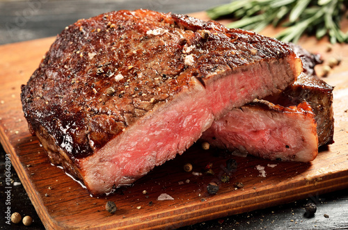 Cuadros en Lienzo Medio chuletón de carne rara en la tabla de madera, enfoque seleccionado