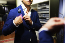 Midsection Of Male Customer Adjusting Handkerchief On Suit At Clothing Store
