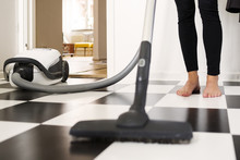 Low Section Of Woman Cleaning Floor With Vacuum Cleaner