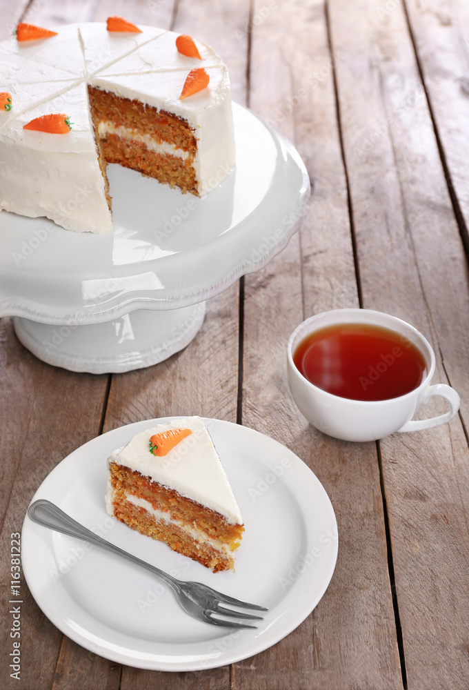Delicious carrot cake with tea on wooden table