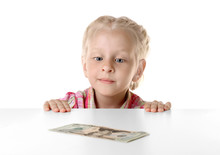 Funny Little Girl Hiding Behind White Table And Looking At Dollar