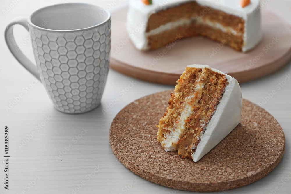 Tasty slice of carrot cake on cork plate