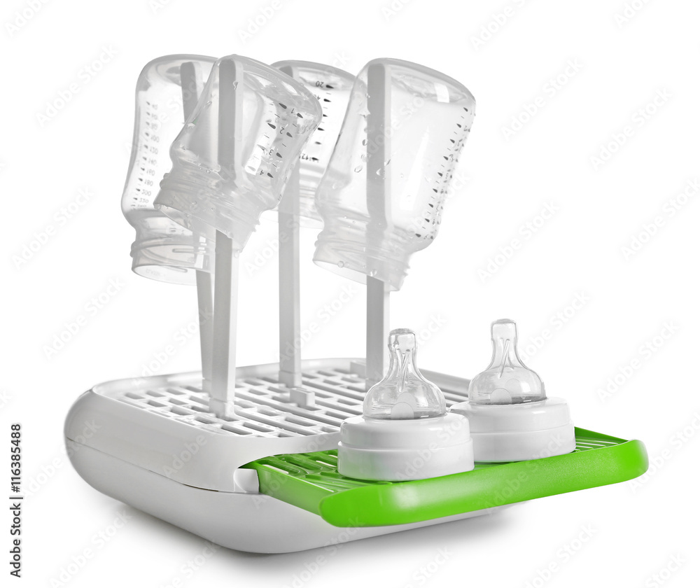 Baby bottles on plastic drying rack on white background
