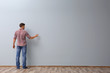 © Africa Studio - Man writing something on grey wall