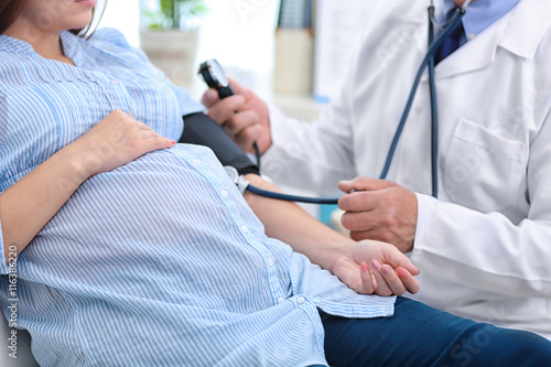 Fotografie, Obraz Doctor measuring pressure of the pregnant woman