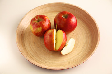 Wall Mural - Red apples on a wooden plate on the table