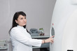 © Ravil Sayfullin - A brunette female doctor pushing control button on CT scanner. Computerised tomography