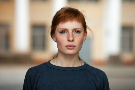 Young redhead caucasian woman serious face outdoor portrait