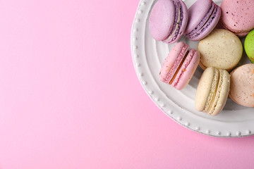 Wall Mural - Tasty colorful macaroons in white plate on pink background