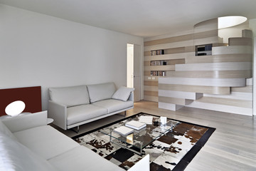 modern living room in foreground the leather sofa a carpet the floor is made of wood