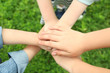 © Africa Studio - Children holding hands together on grass background