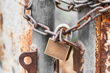 Vintage rusty gate with locked master key and chain