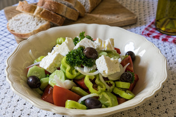 Wall Mural - Traditional greek salad, served with bread on table