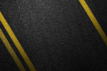 Level asphalted road with a dividing yellow stripes. The texture of the tarmac, top view.