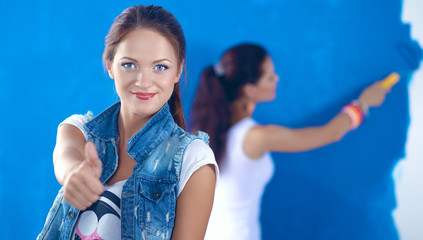 Two Beautiful young woman doing wall painting