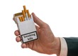 © vchalup - Man holds cigarette pack in hand with warning label that smoking kills. Isolated on white background.