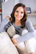 © shefkate - Portrait of happy young woman sitting on sofa