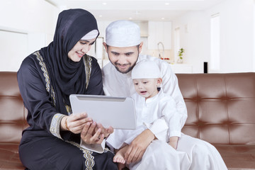 Wall Mural - Arabian family playing tablet on sofa