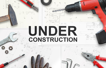 Under construction text with tools for home repairs. Top view.