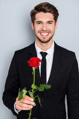 Wall Mural - Handsome businessman with beaming smile holding red rose