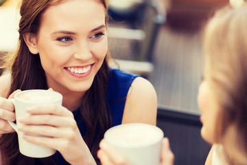 Sticker - smiling young women with coffee cups at cafe