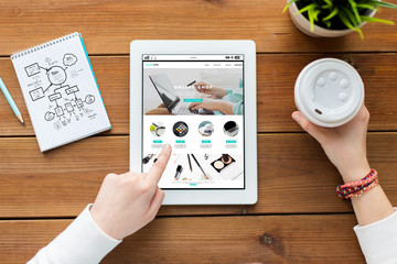 Poster - close up of woman with tablet pc on wooden table