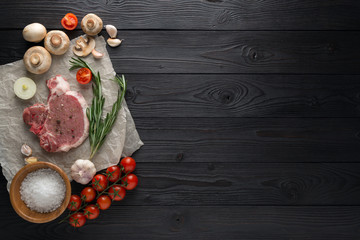 Wall Mural - Raw pork cutlet with spices and Ingredients for grill or cooking on wooden background