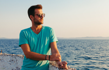 Beautiful man on the dock looking at sunset