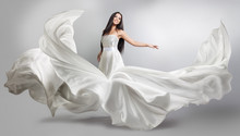Beautiful Young Girl In Flying White Dress. Flowing Fabric. Light White Cloth Flying In The Wind