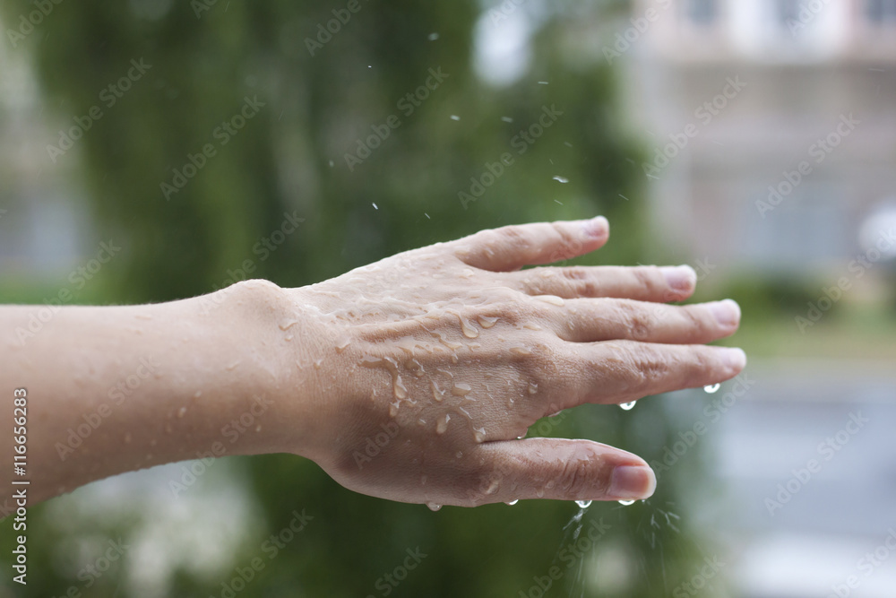 Feel the rain on your skin, woman's hand on rainy day Stock Photo