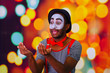 © Fotos 593 - Pantomime man with facial paint posing for camera holding blowing horn, blurry lights background