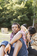 © Astrakan Images - Portrait of man relaxing in forest with female friends in background