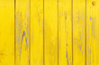 Vertical background of the wooden planks with cracked yellow paint