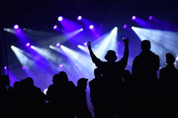 Silhouette of concert crowd in front of bright stage lights