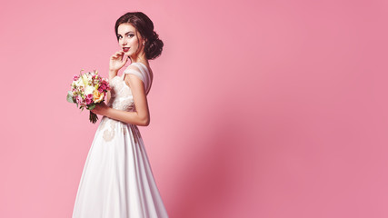 bride.young fashion model with perfect skin and make up, beige background, curly hair, flowers in ha