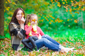 Wall Mural - Adorable little girl with mother in autumn park outdoors