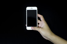 Female hand holding the iPhone 5 gold isolated on Black background