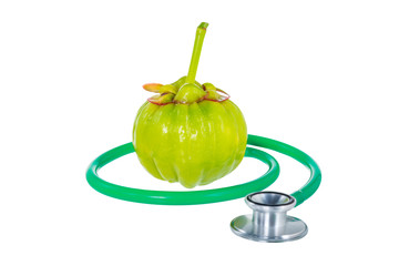 Wall Mural - Close up garcinia cambogia and stethoscope on white background.