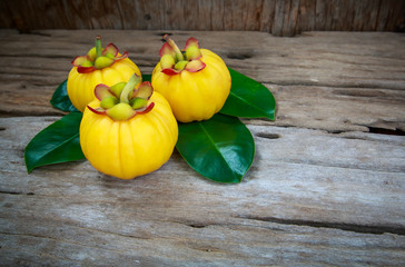 Wall Mural - Garcinia cambogia fresh fruit on wood background.  Fruit for diet