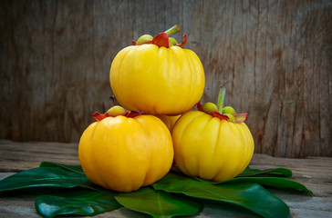 Wall Mural - Garcinia cambogia fresh fruit on wood background.  Fruit for diet