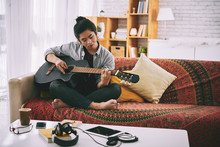 Vietnamese Creative Man Playing Guitar At Home