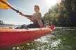 © Jacob Lund - Senior woman canoeing in lake on a summer day