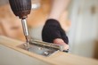 © Wavebreak Media - Carpenter tightening screw to hinges on a wooden door