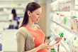 © Syda Productions - happy pregnant woman choosing lotion at pharmacy