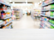 © fascinadora - Wooden empty table in front of blurred supermarket