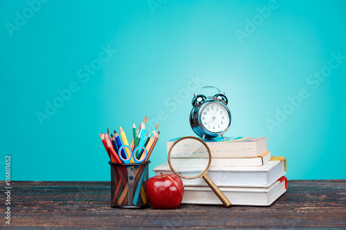 Stampe Back to School concept. Books, colored pencils and clock
