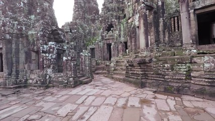 Canvas Print - Ancient, paved courtyard and intricately sculpted buildings comprise the famous and historical Bayon Temple ruin near Siem Reap, Cambodia. UltraHD video