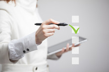 Young Business Woman Checking On Checklist Box. Gray Background.