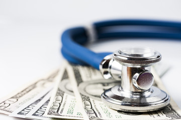 Healthcare cost concept: stethoscope and dollars isolated on white.