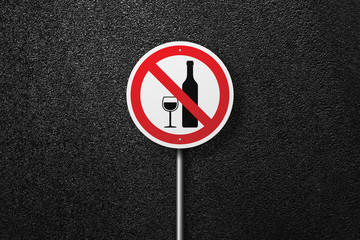 Road sign of the circular shape on a background of asphalt. No alcohol. The texture of the tarmac, top view.